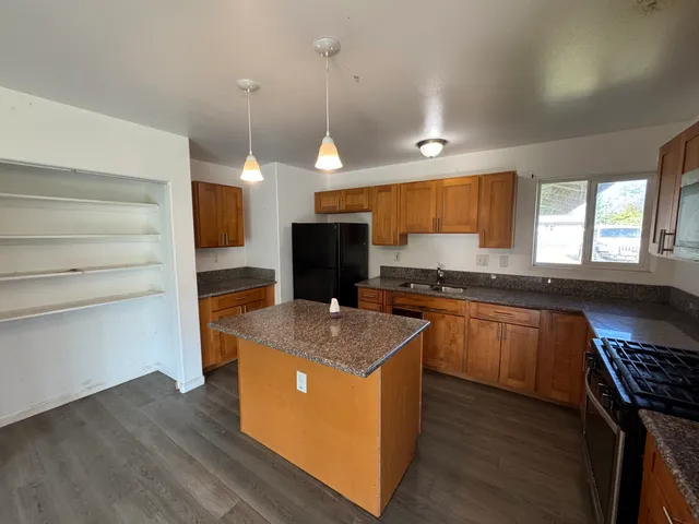 a kitchen with stainless steel appliances granite countertop a stove a sink and a microwave