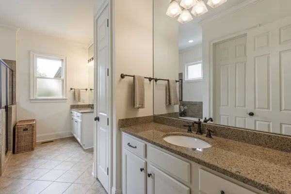 a bathroom with a granite countertop sink a toilet and a mirror