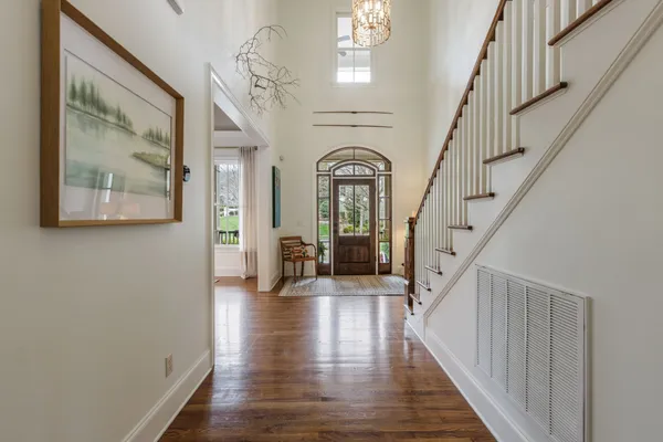 a kitchen with stainless steel appliances granite countertop a stove top oven a sink a dining table and chairs with wooden floor