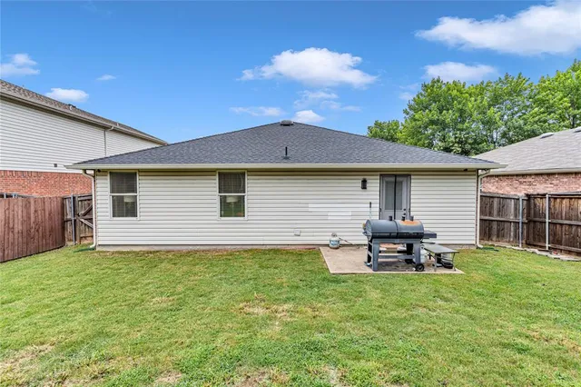 a backyard of a house with table and chairs