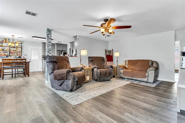 a living room with furniture a ceiling fan and a rug