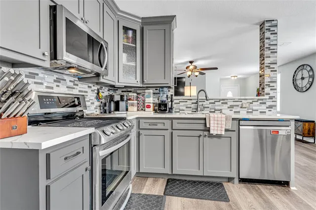 a kitchen with stainless steel appliances granite countertop a stove a sink and a microwave