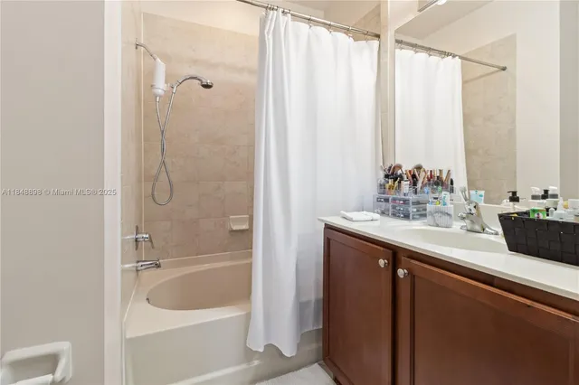 a bathroom with a double vanity sink a large mirror and shower