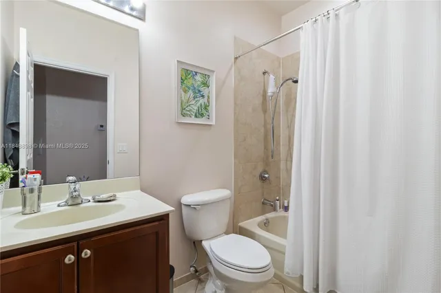 a bathroom with a toilet a sink a mirror a vanity and shower