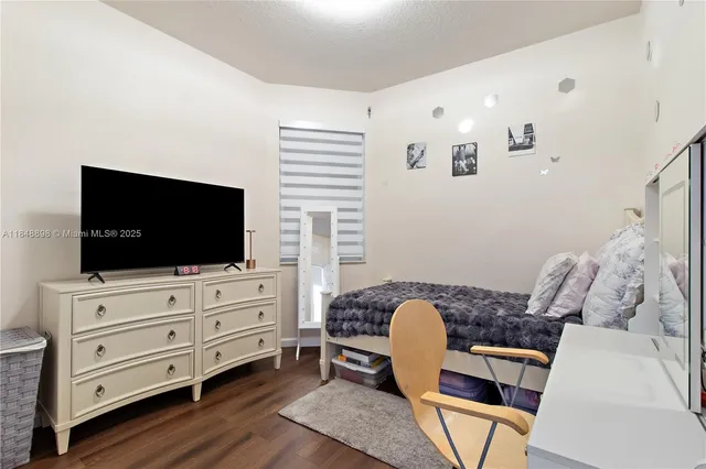 a bedroom with furniture and a flat screen tv
