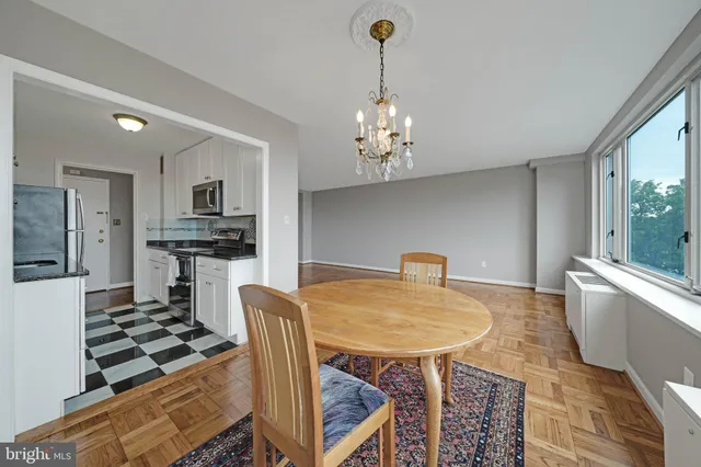 a kitchen with stainless steel appliances granite countertop a stove a sink dishwasher a dining table and chairs with wooden floor