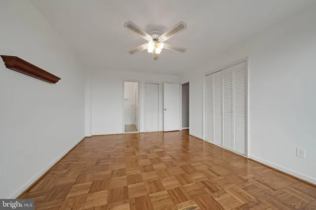 a view of an empty room with window and a ceiling fan