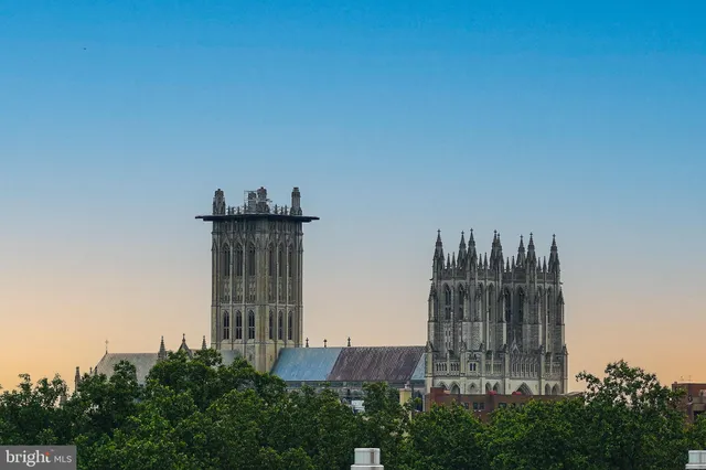 a view of a large building with a big yard and large trees