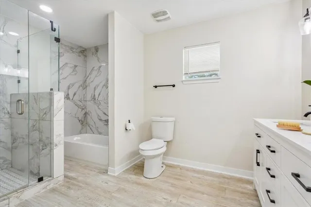 a bathroom with a sink a toilet and shower
