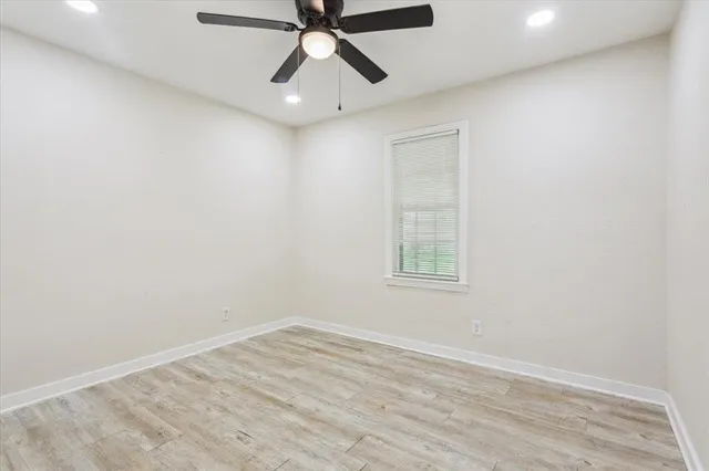 an empty room with a window and a fan