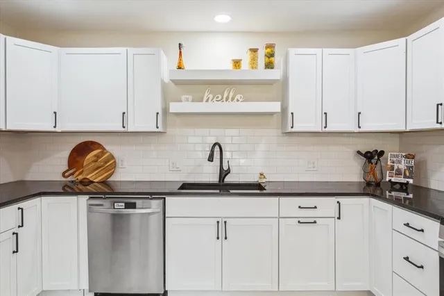 a kitchen with granite countertop white cabinets and a sink