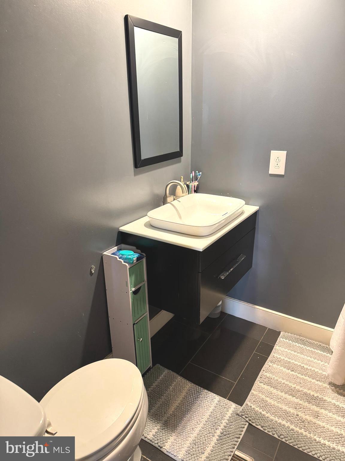 1800 Bel Air Road, Unit 66 Woodbridge, VA 22191 - Photo 13 of 18 a bathroom with a sink a toilet a mirror and vanity