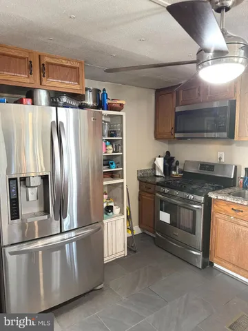 a kitchen with stainless steel appliances granite countertop a refrigerator a stove and a sink