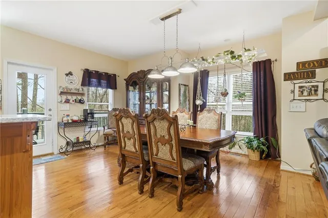 a kitchen with stainless steel appliances granite countertop a dining table chairs refrigerator and sink