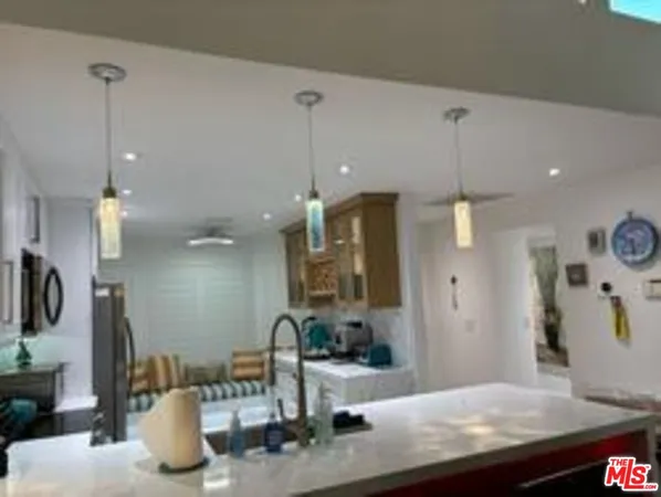 a kitchen with kitchen island a sink stainless steel appliances and cabinets