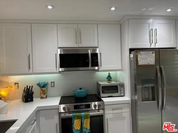 a kitchen with stainless steel appliances a stove a microwave a sink and cabinets