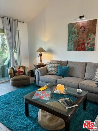 a living room with furniture a rug and a lamp