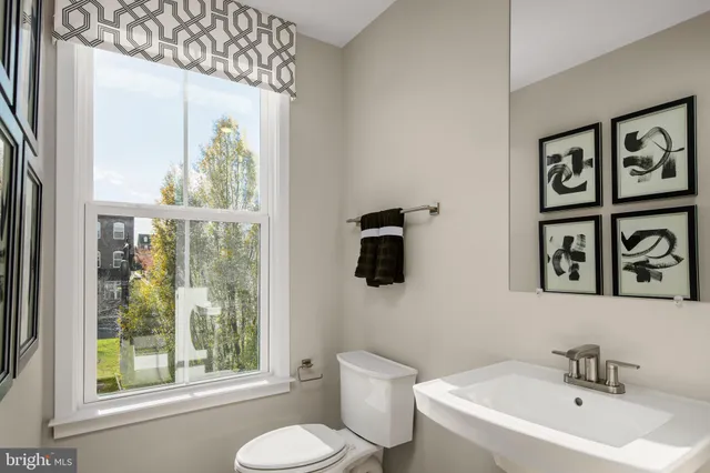 a bathroom with a toilet sink a window and a shower