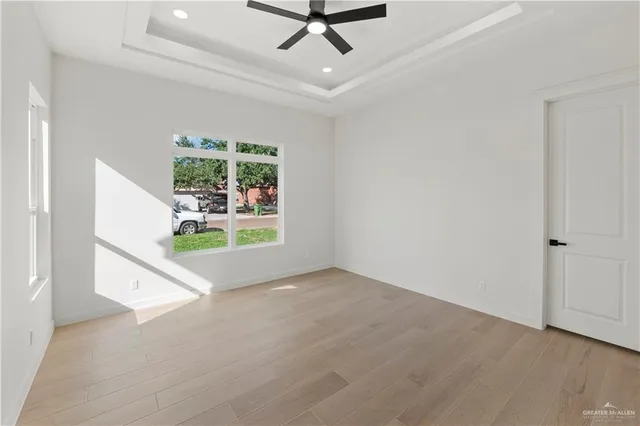 an empty room with windows and ceiling fan