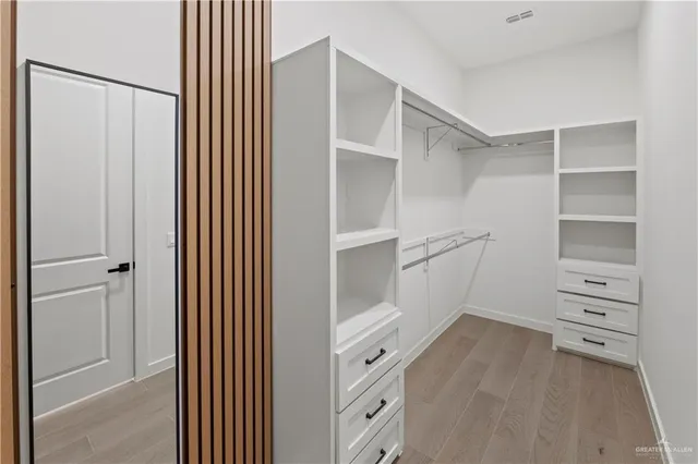 a view of walk in closet with empty racks