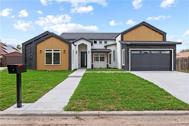 a front view of a house with a yard and garage