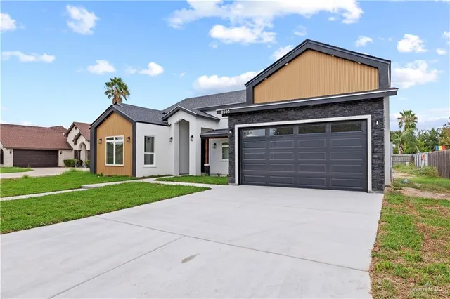 a front view of a house with a yard and garage