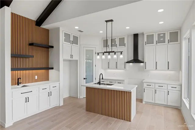 a kitchen with white cabinets and sink