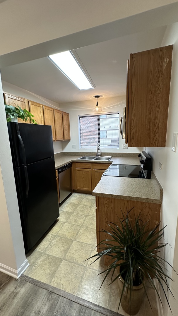 413 Berkshire Drive, Unit 22 Crystal Lake, IL 60014 - Photo 3 of 14 a kitchen with a sink a refrigerator and wooden floor