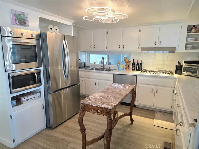 a kitchen with stainless steel appliances a stove a sink refrigerator and cabinets