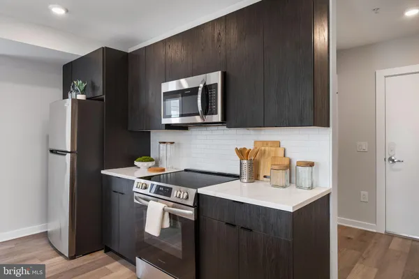a kitchen with stainless steel appliances a stove microwave and refrigerator