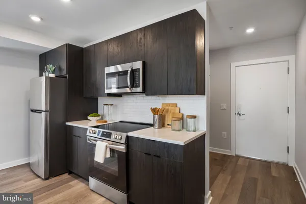 a kitchen with stainless steel appliances granite countertop a refrigerator stove and sink