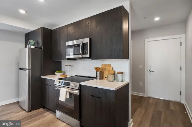 a kitchen with stainless steel appliances granite countertop a refrigerator stove and sink