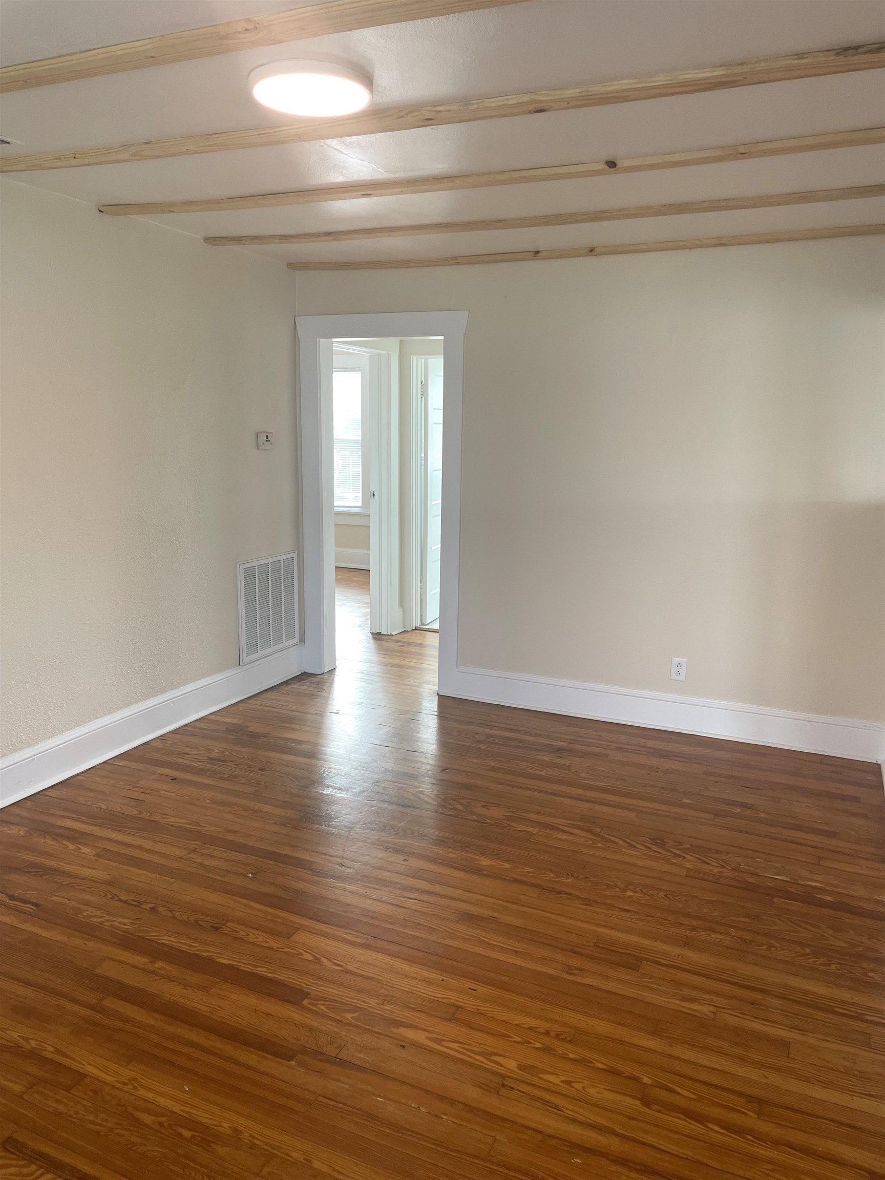 143 A Riberia Street St. Augustine, FL 32084 - Photo 2 of 11 Empty room featuring dark wood-type flooring and beamed ceiling