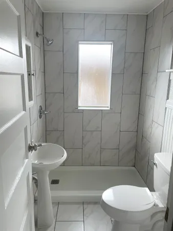 a bathroom with a sink a toilet a mirror and bathtub