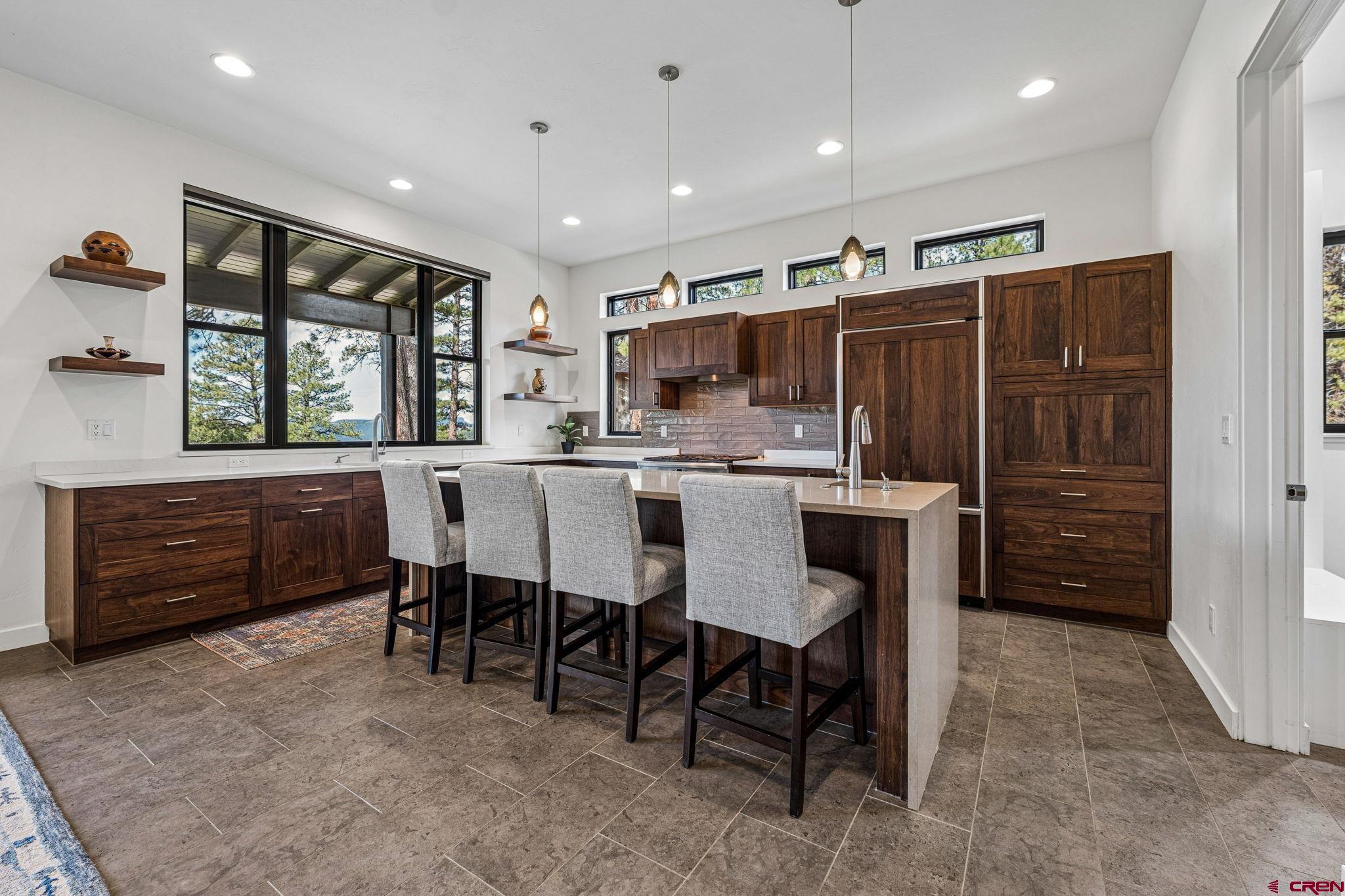 201 Window Lake Trail Durango, CO 81301 - Photo 14 of 45 a kitchen with kitchen island a dining table chairs and white cabinets