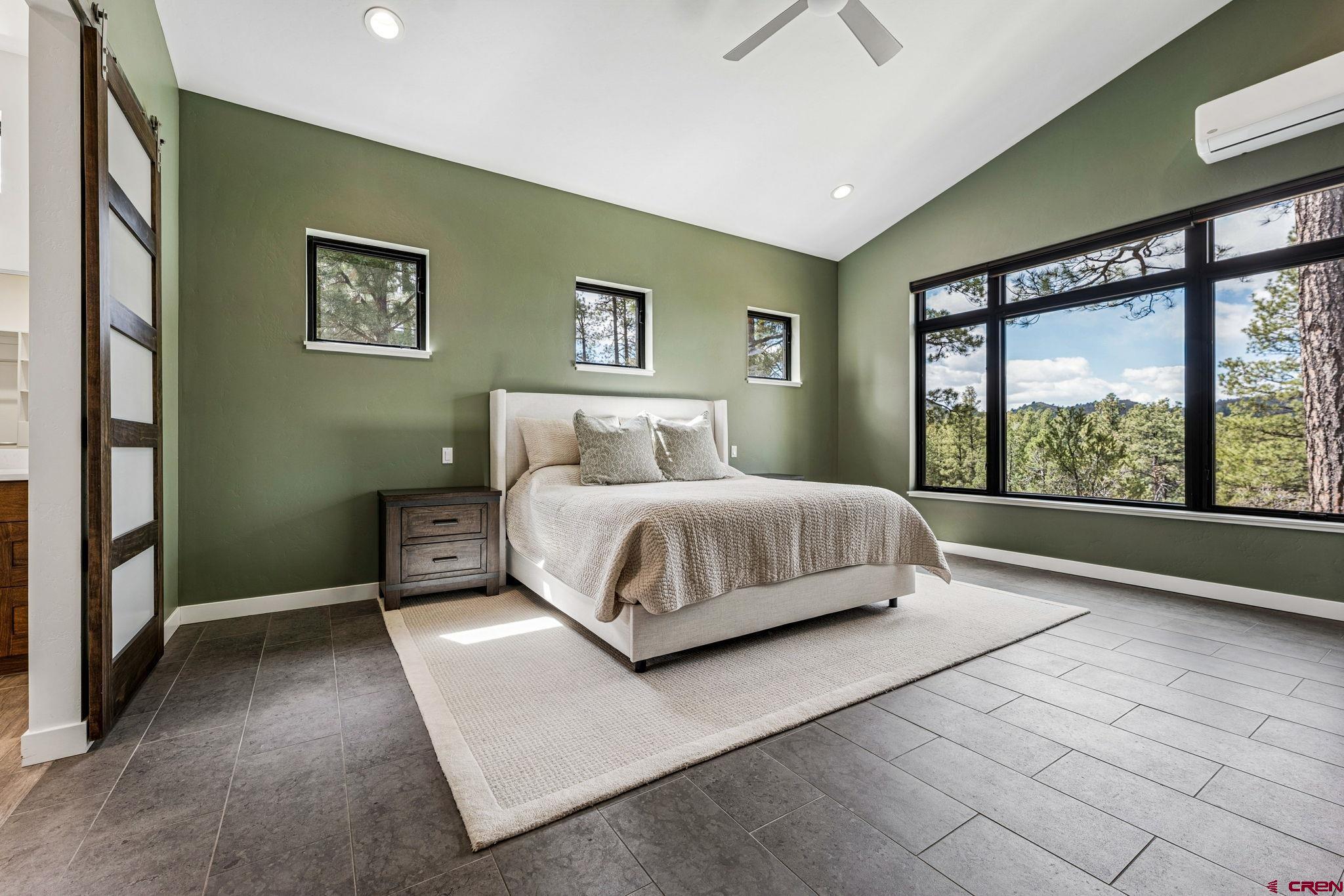 201 Window Lake Trail Durango, CO 81301 - Photo 21 of 45 a bedroom with a large bed and a chandelier