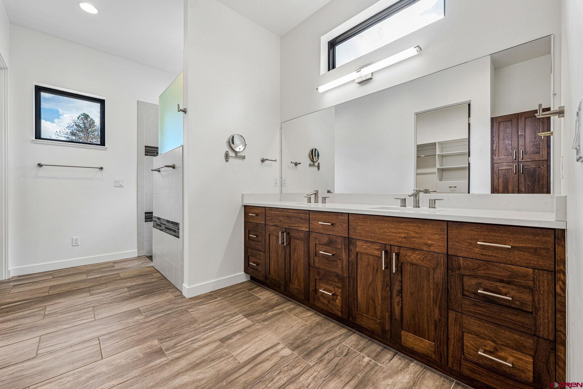 201 Window Lake Trail Durango, CO 81301 - Photo 22 of 45 a spacious bathroom with a double vanity sink a large mirror and a shower