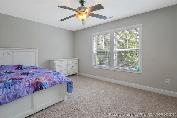 a bedroom with a bed and a chandelier fan