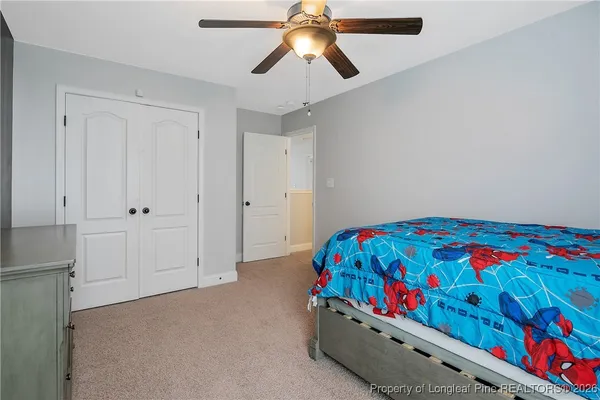 a bedroom with a bed and a chandelier fan