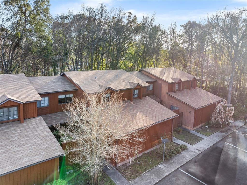 an aerial view of a house with yard and seating space