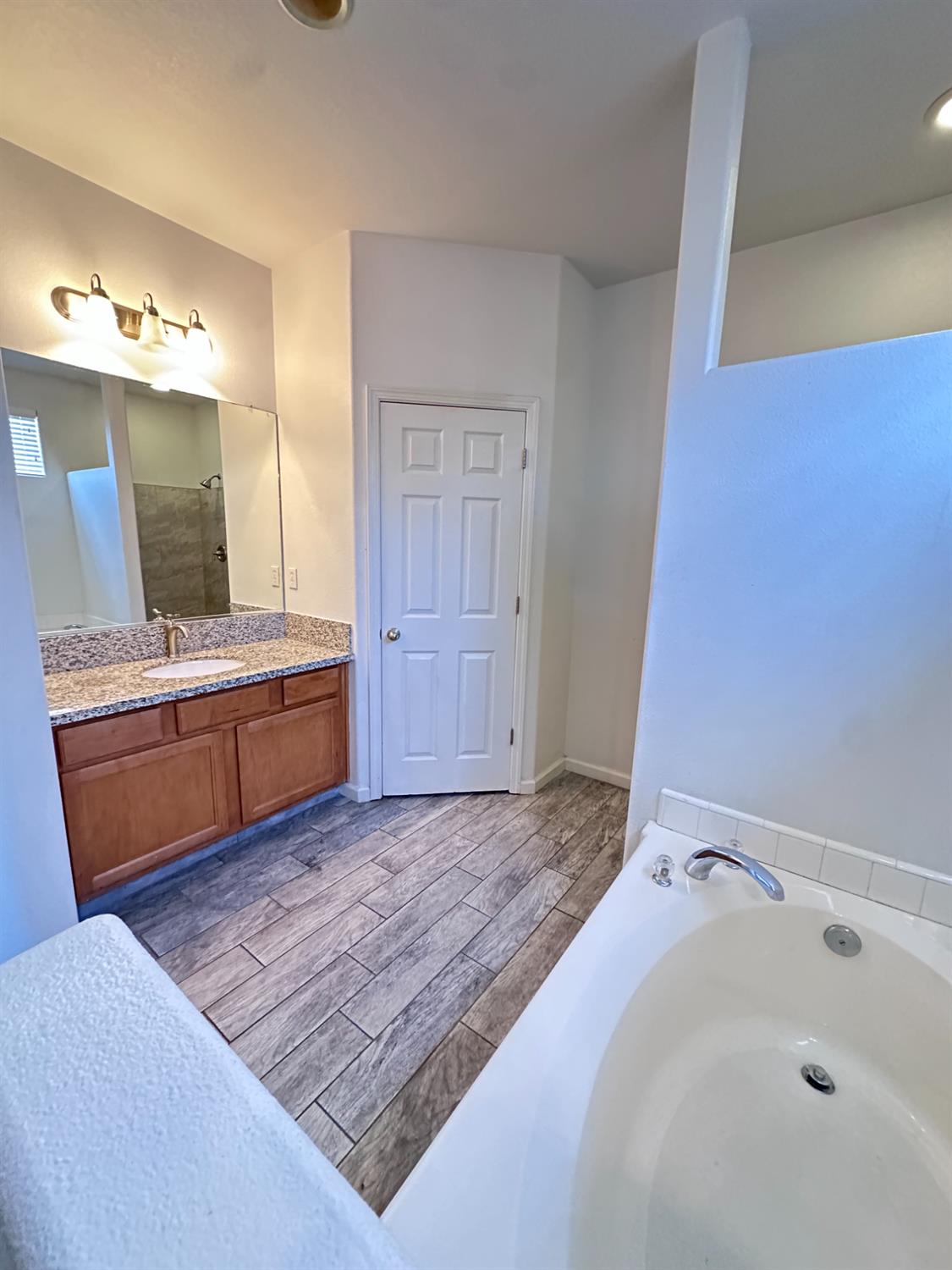 6642 East Cetti Avenue Fresno, CA 93727 - Photo 12 of 18 a en suite bathroom with a tub sink and mirror