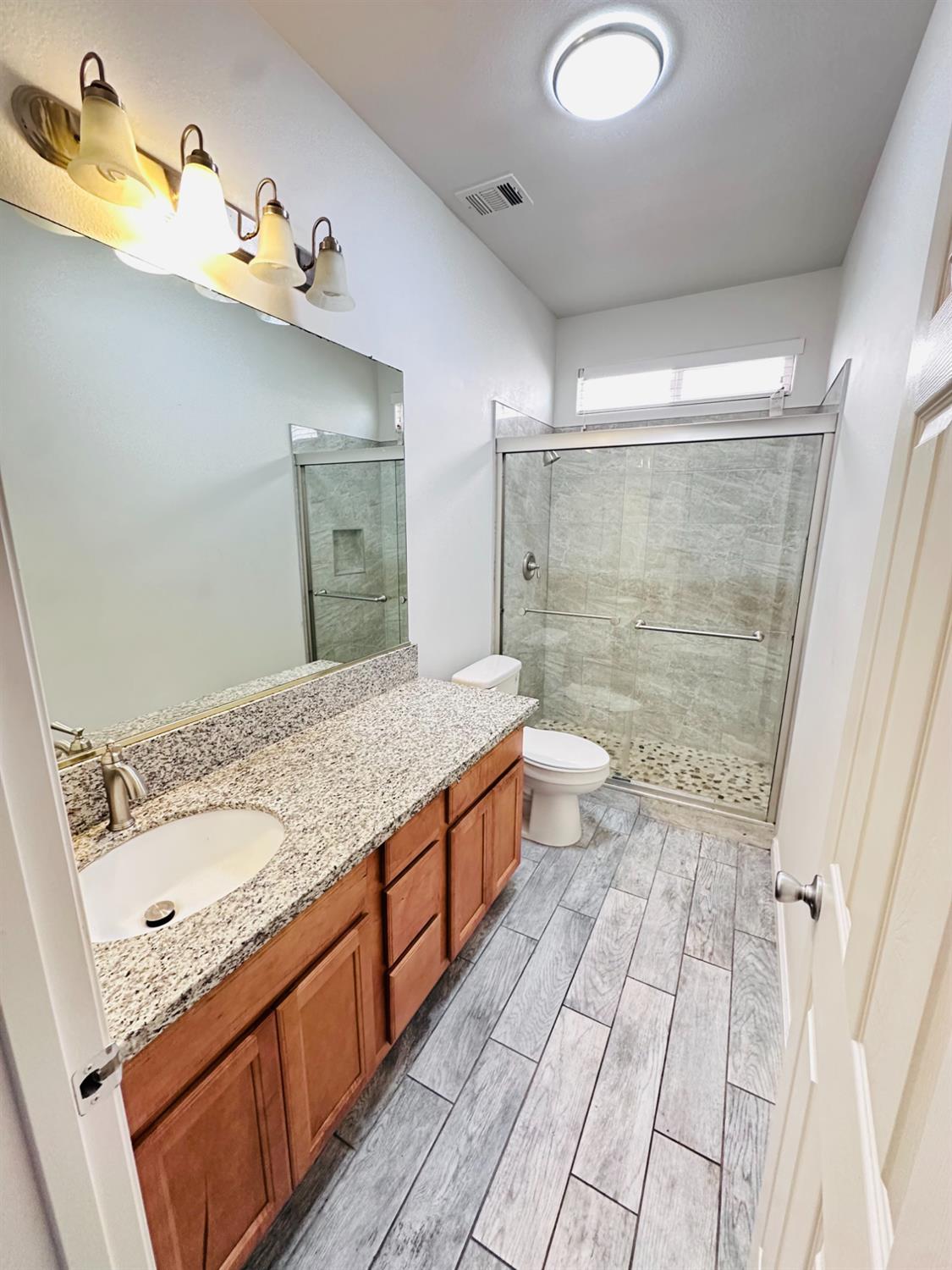 6642 East Cetti Avenue Fresno, CA 93727 - Photo 18 of 18 a bathroom with a granite countertop sink toilet and shower