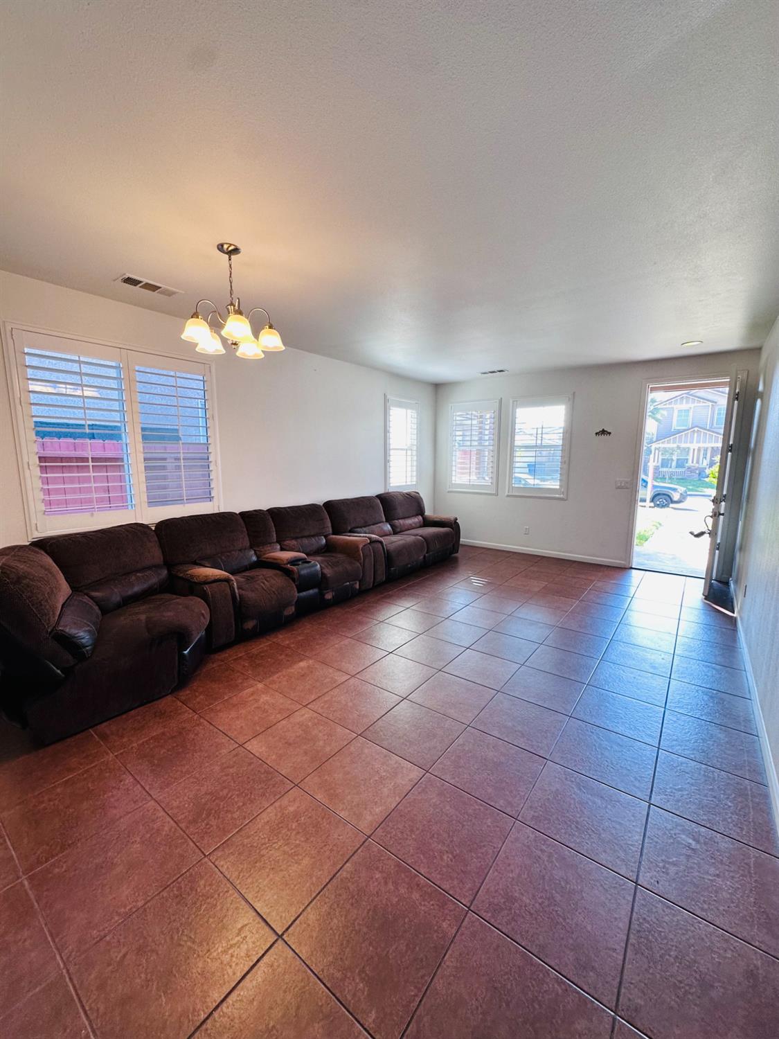 6642 East Cetti Avenue Fresno, CA 93727 - Photo 5 of 18 a living room with a black white checkered floor with couches and chandelier
