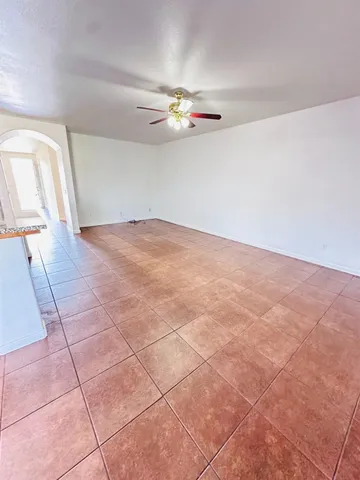 an empty room with windows and ceiling fan