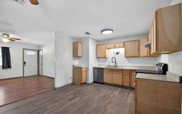 a kitchen with a sink cabinets and wooden floor