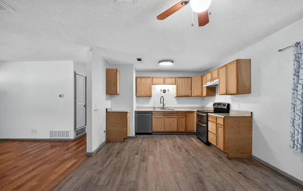 a large kitchen with a wooden floor and stainless steel appliances