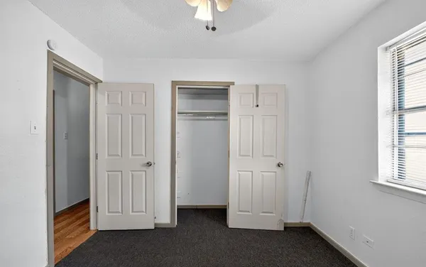 an empty room with a chandelier fan