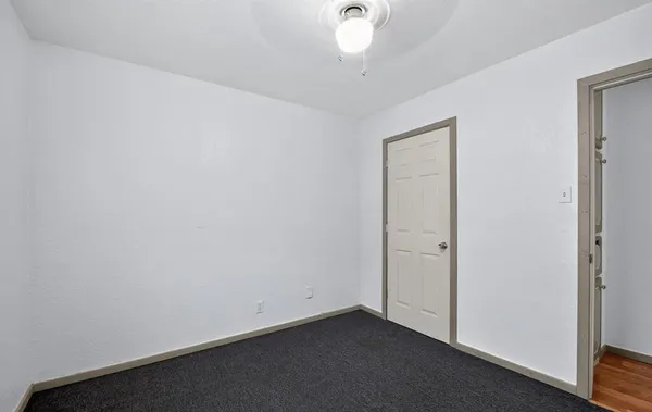 a view of a hallway with a livingroom and a bathroom