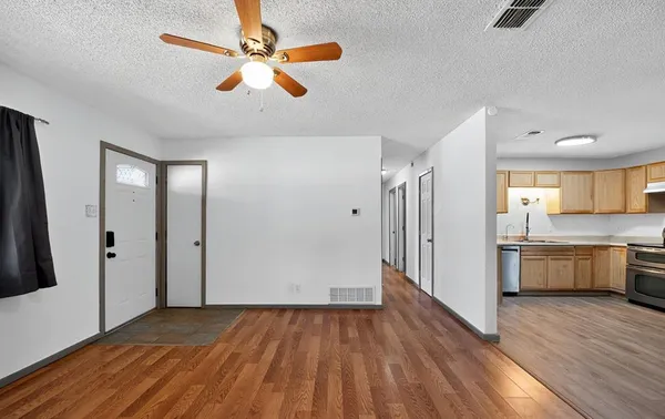 wooden floor in an empty room with a kitchen
