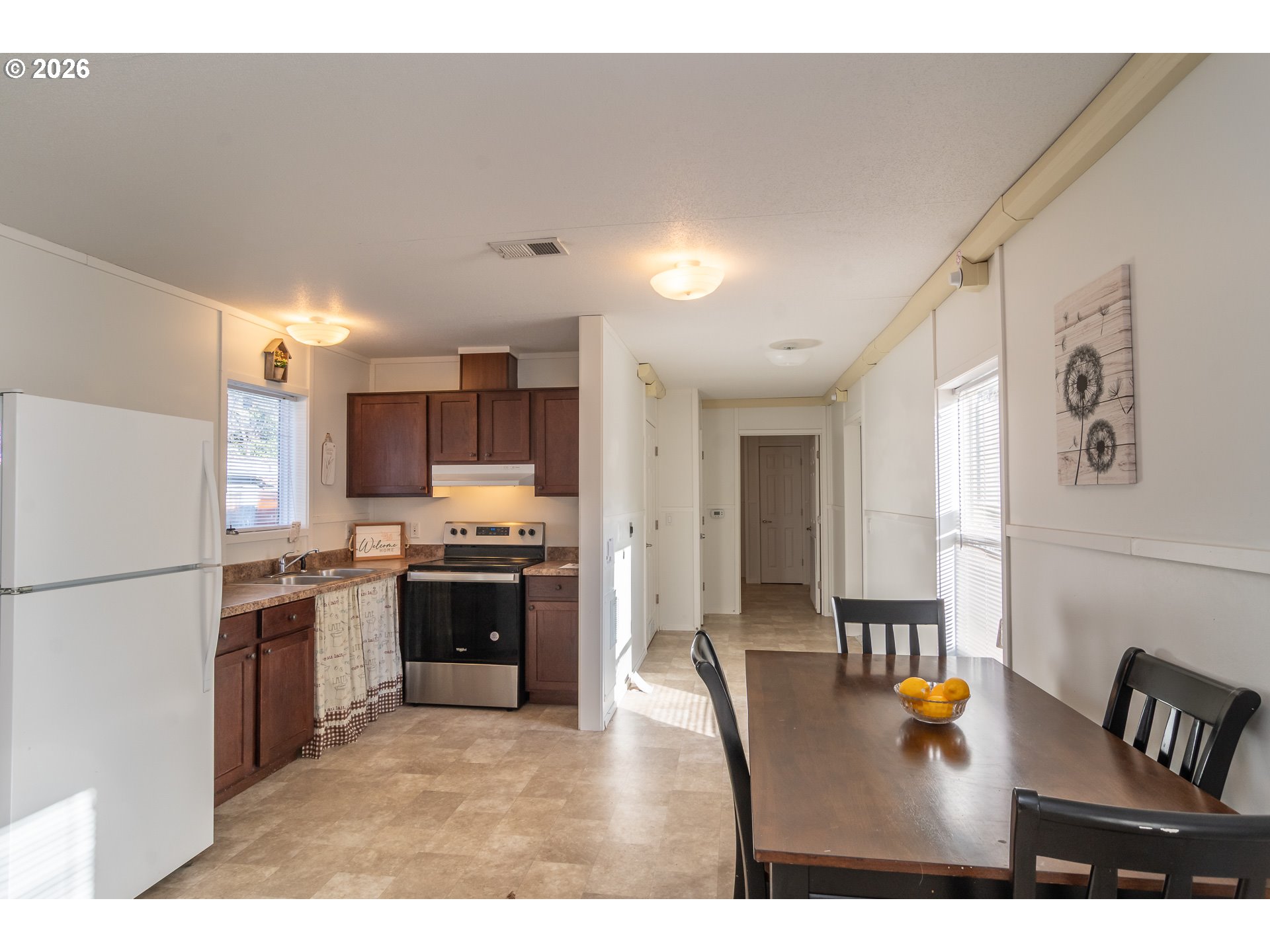 5000 Northeast Stephens Street, Unit 40 Roseburg, OR 97470 - Photo 13 of 27 a kitchen with stainless steel appliances granite countertop a refrigerator a stove a sink dishwasher and white cabinets with wooden floor